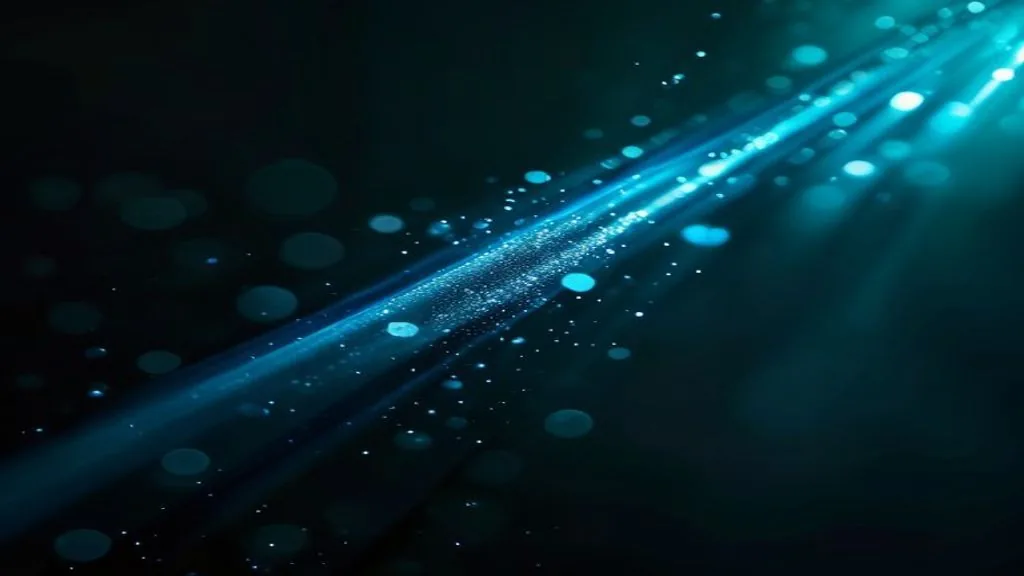 A shaft of blue light cutting diagonally across a dark background, with fine particles scattered through the beam